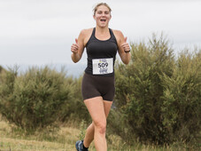 Woman Running. Happy strong, smiling. At blazing hills thumbs up.