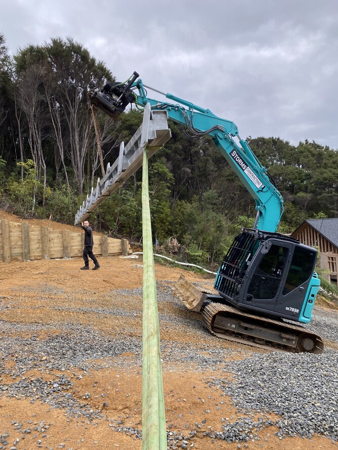 8-tonne excavator assisting with the installation of a waler beam on-site.