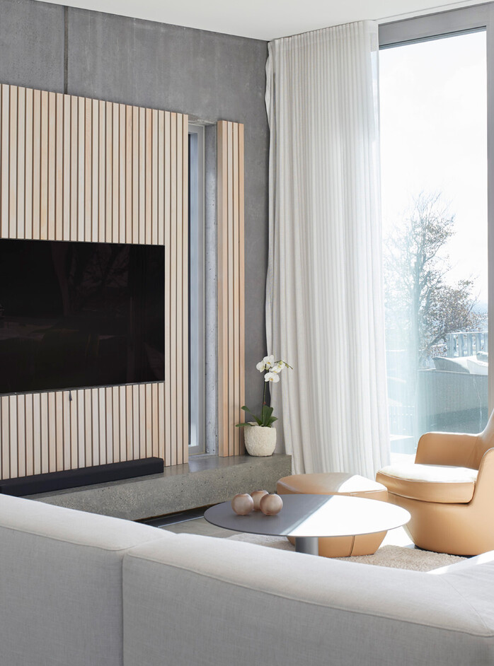 Living room with polished concrete and vertical natural timber entertainment feature