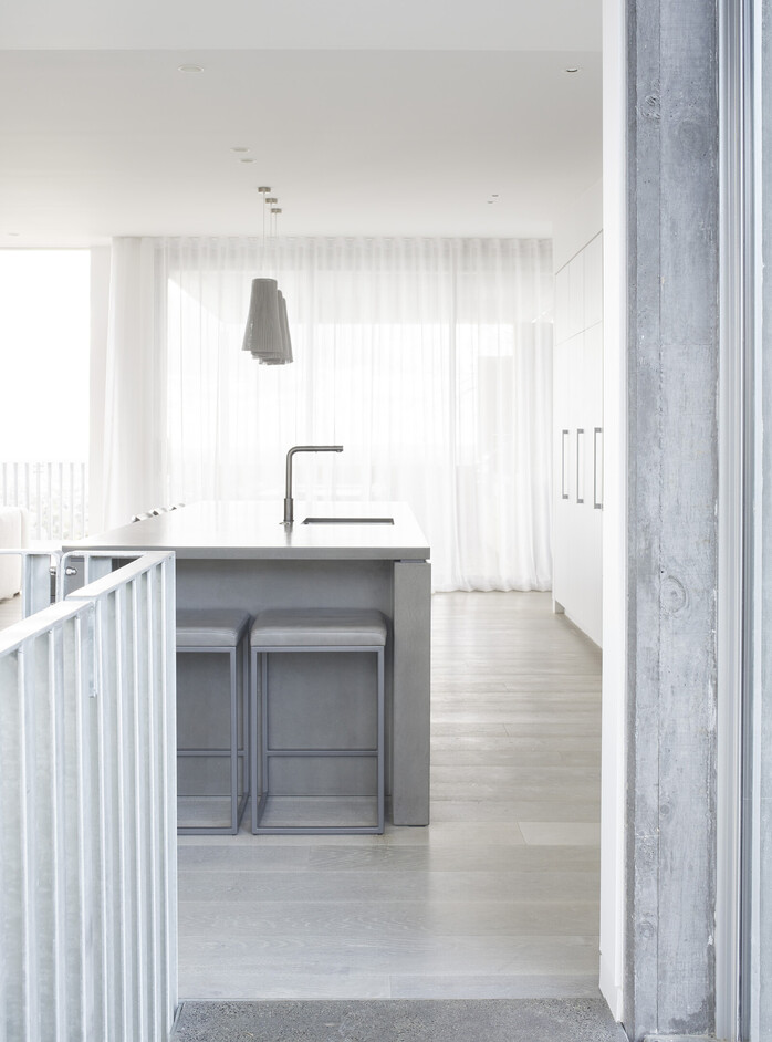 Kitchen island with polished bench top and luxury pendants