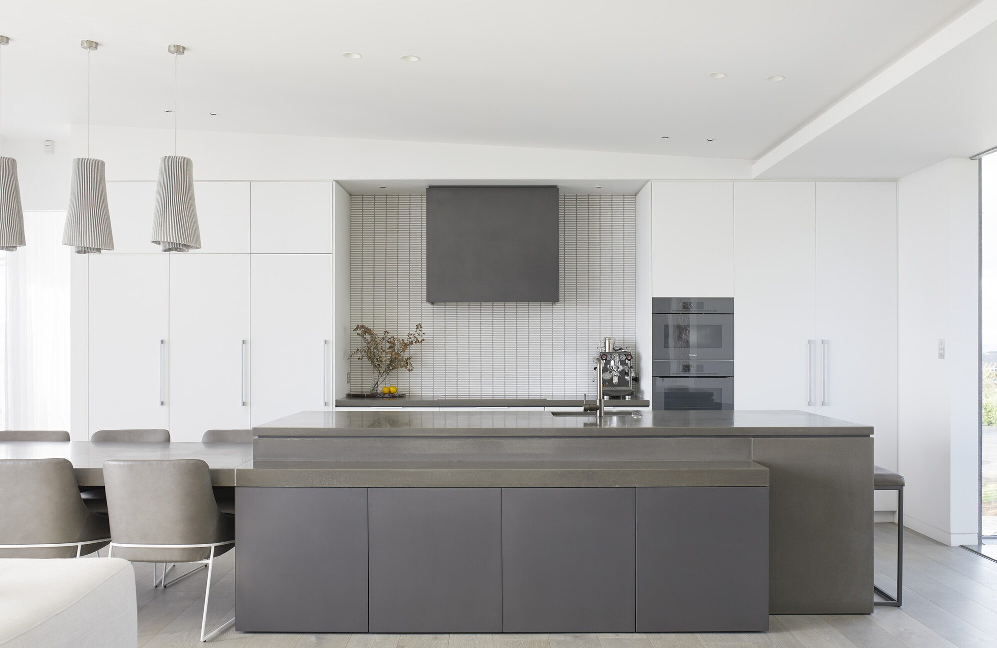 High end kitchen with polished benchtop and crisp white cabinetry
