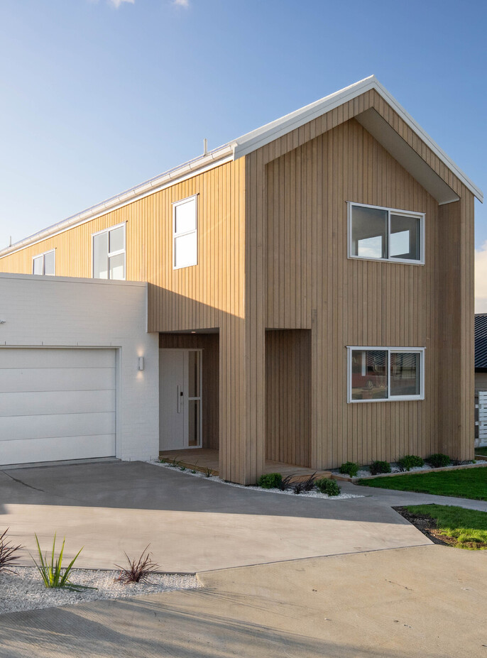Modern two storey home with vertical timber cladding and contrasting white brick garage
