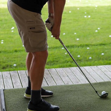Man with golf club on driving range in Warkworth