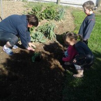 Kids and in-home educator gardening