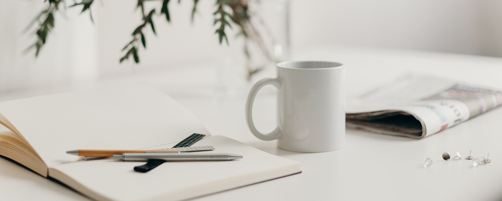 Image of a notebook and white coffee mug on a table. Image for CVs by Sarah website. CV, Cover Letter & LinkedIn Profile writer. New Zealand. Photo credit: Cotton Bro via Pexels