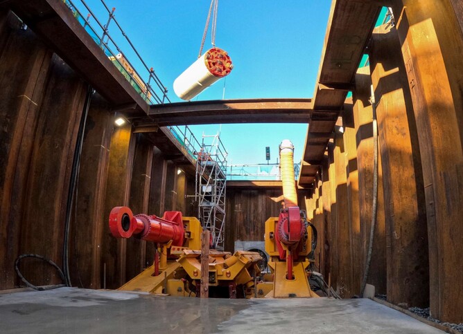 The tunnel boring machine (TBM) is lowered into the launch site by crane