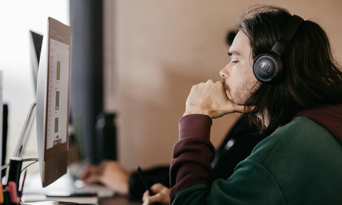 Man with long hair at working on a computer