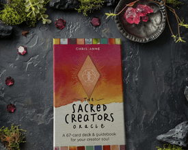 The Sacred Creators Oracle Deck on a moss and gem background with crystals