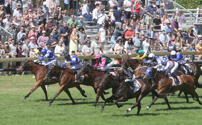 Mai Tai (centre, black colours) bursts to the lead in front of the large crowd on-course at Ellerslie on Boxing Day - Photo credit: Trish Dunell