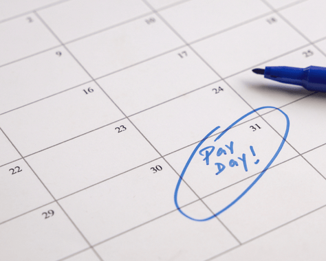 Monthly calendar with pay day circled reflecting on Payroll. Blue pen is showing