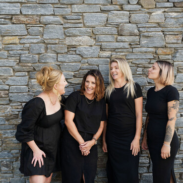 The Salon staff lined up outside The Salon laughing together.