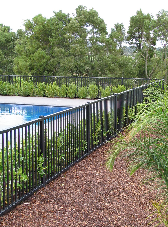 photo of a beautiful pool surrounded by garden and trees with a Moduline PoolSide fence
