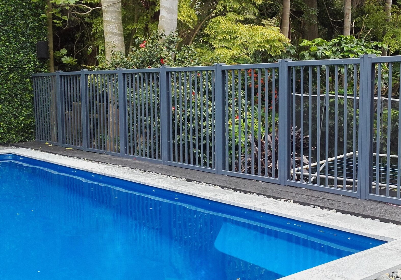 photo of a pool with beautiful garden surround, and Moduline barrier fencing to provide a safety barrier over the high drop