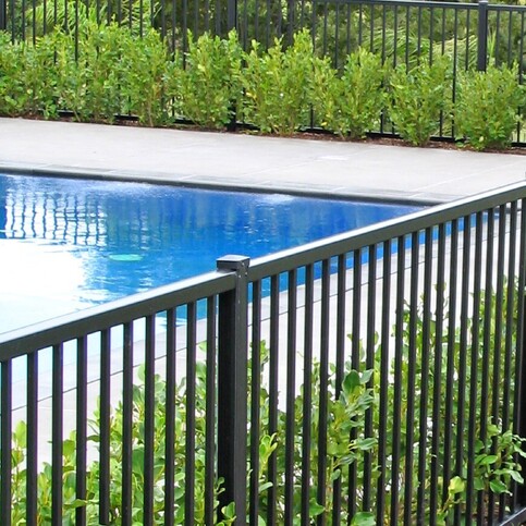 photo of a beautiful pool surrounded by garden and trees, with Moduline PoolSide fencing for safety