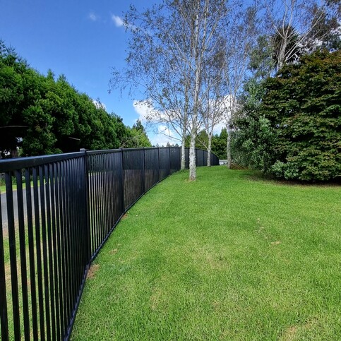 photo of a serene driveway in the country, with lush grass and trees, with Moduline boundary fencing for security