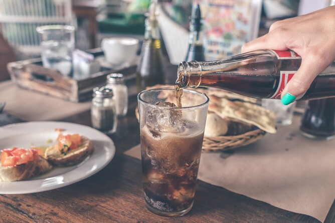 a woman serving a coke to the customer