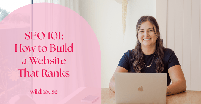 Web designer smiling and working on a laptop, next to the text 'SEO 101: How to Build a Website That Ranks' in a pink overlay, with the Wildhouse Design Studio logo