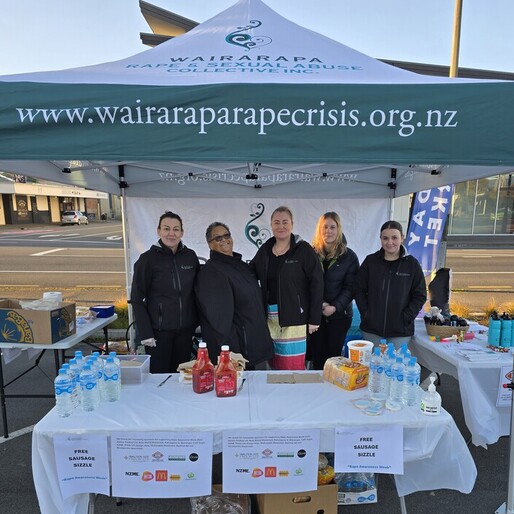 Wairarapa Rape and Sexual Abuse Collective Inc. team at 2025 Rape awareness week hosting a sausage sizzle in a branded tent