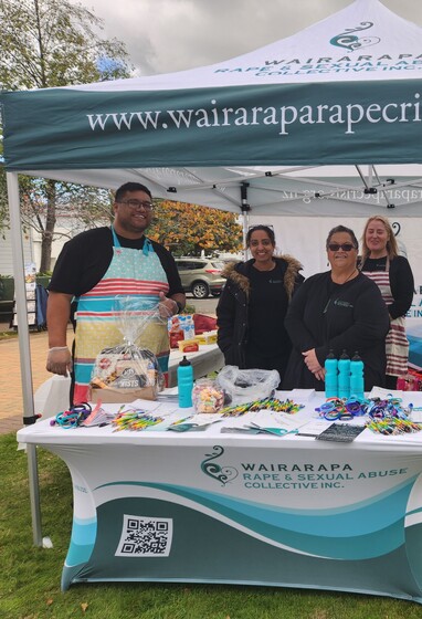 Wairarapa Rape and Sexual Abuse Collective Inc. team at 2024 Rape awareness week hosting a sausage sizzle in a branded tent