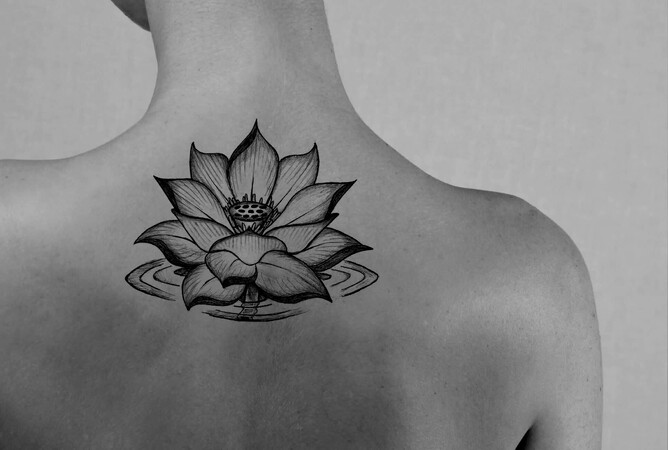 Girl with lotus flower tattoo on back