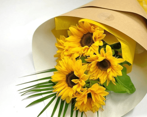 Surprise someone with a vibrant bouquet of fresh sunflowers, beautifully paired with seasonal foliage