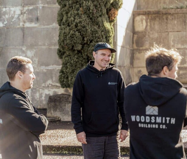 The Woodsmith Building Co team in a morning meeting onsite in Auckland, ready to work on a renovation building project