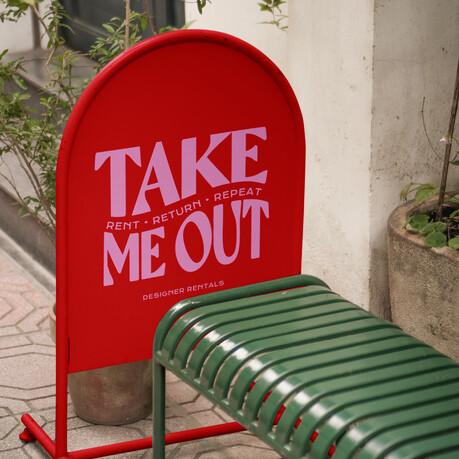 Outdoor stand signage design for 'Take Me Out' dress rental, bold colourings and text