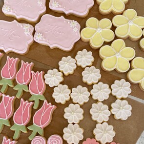 Gluten free pale pink meringues with striped chocolate detail raspberry dust sprinkles and gold balls two strawberries decorate the edge of the photo