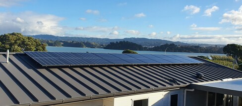 Solar panels installed on roof in the Bay of Plenty, water and hills in the background