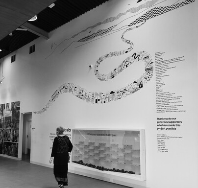 Woman walking past a wall with a large illustration