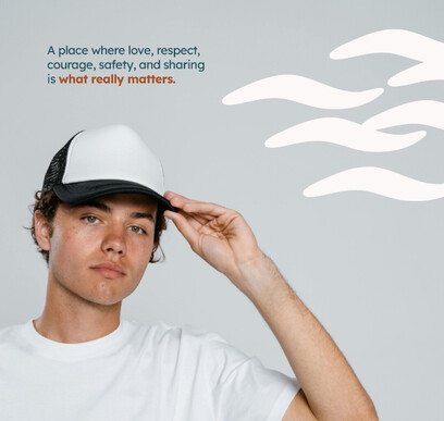 Teenage boy holding cap with text above.