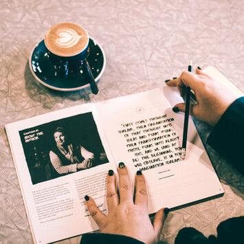 Dream, Plan, Be book open at a cafe with coffee