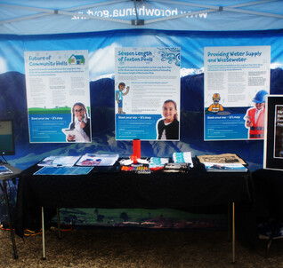 Table at consultation event with promotional items and information boards
