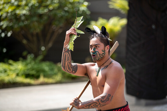Māori warrior performing a traditional pōwhiri (welcome ceremony) greeting