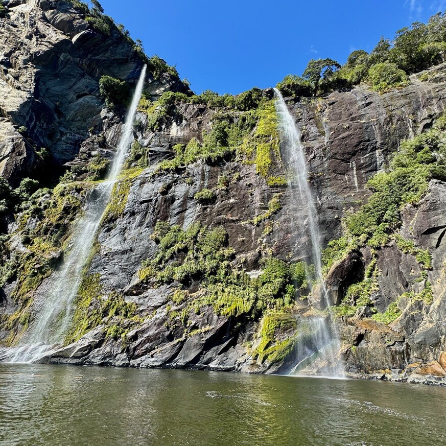 Waterfalls at Milford Sound surrounded by cliffs