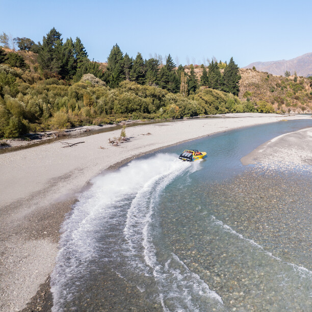 Drone shot of the luge track winding down the hillside in Queenstown with lake and mountain views in the background.