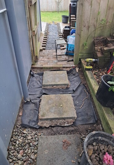 Cement pavers and pebbles next to a house