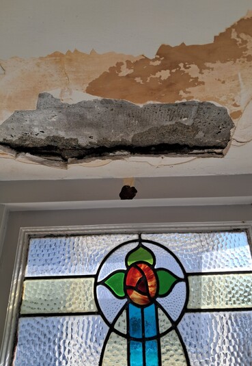 Stained glass window and ceiling with plaster damage