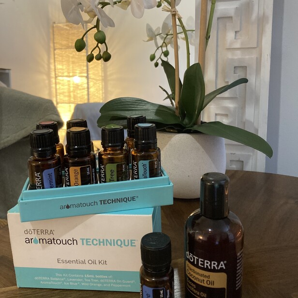 picture of the 8 doterra essential oils on a table next to an orchard in a massage room and a large light in the corner of the room