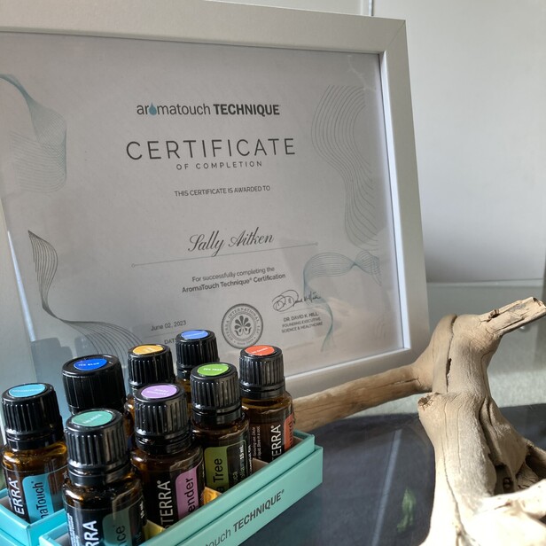 Picture of a certificate and 8 essential oils for the aromatouch technique