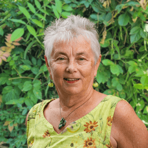 Photo of woman with short grey hair in front of brick wall