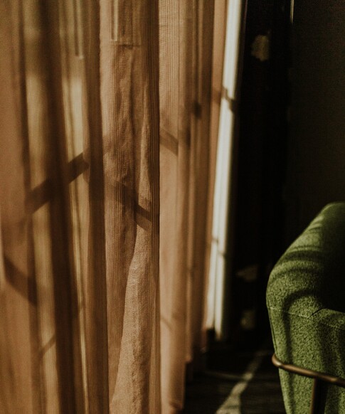 image of sheer curtain and green chair.