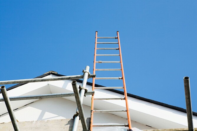 tall ladder and scaffolding against side of house