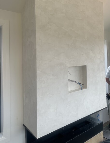 A feature fireplace microcement finished by Pro Stop Interiors Queenstown.