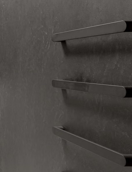 A dark microcement bathroom wall with towel rails on it.