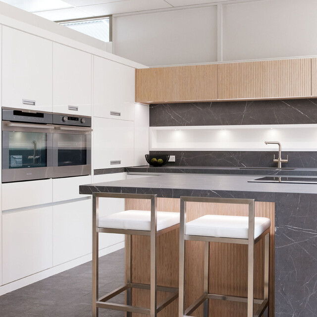 Modern kitchen with integrated appliances, sleek white cabinetry, and timber details, designed by Barrett Joinery and displayed in their Timaru showroom for custom kitchen inspiration.