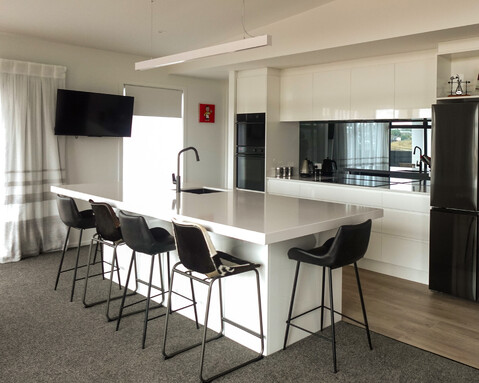 Large freestanding island with integrated seating, blending modern design with functionality by Barrett Joinery.
