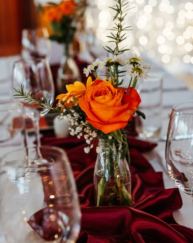 Bold orange flowers on wedding table setup at Markovina Vineyard Estate in Kumeu