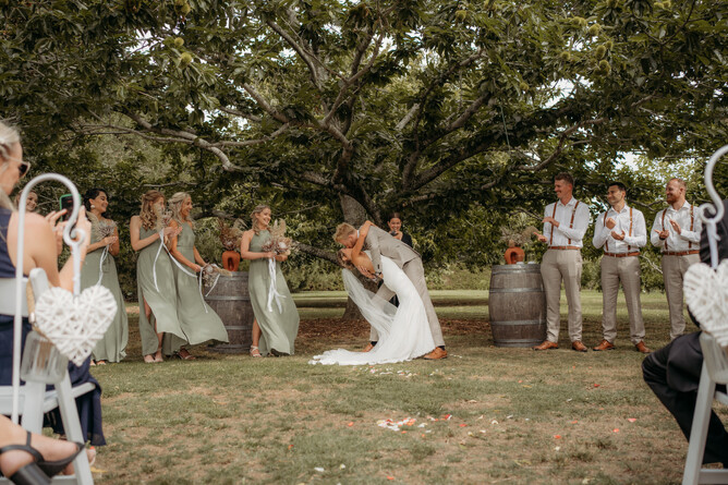 Wedding couple sharing a kiss during their wedding ceremony at Markovina Estate in Kumeu