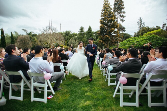 Wedding couple walking down the aisle after their wedding ceremony at the Pebble Beach at Markovina Estate in Kumeu